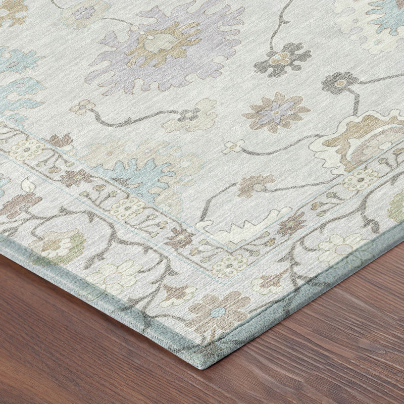 Close-up of light gray rug corner with multicolor floral motifs and blue border