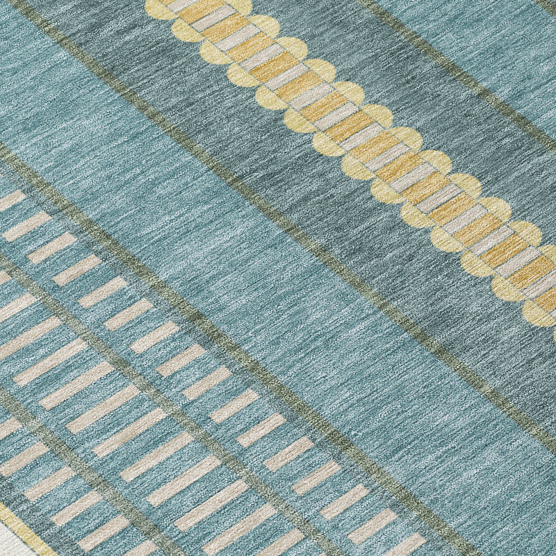 Close-up of teal and cream rug with gold horizontal stripe and geometric pattern.