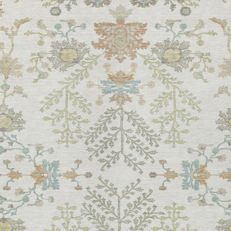 Close-up of ivory area rug featuring symmetrical tree-and-flower motif in muted colors