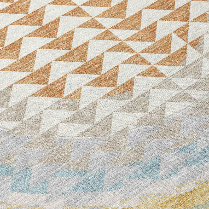 Geometric area rug detail with diagonal white, tan, and burnt-orange diamond pattern.