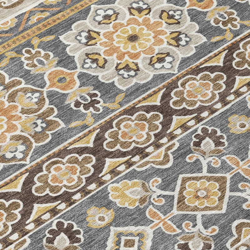Close-up of gray area rug with ivory, tan, and gold ornamental motifs