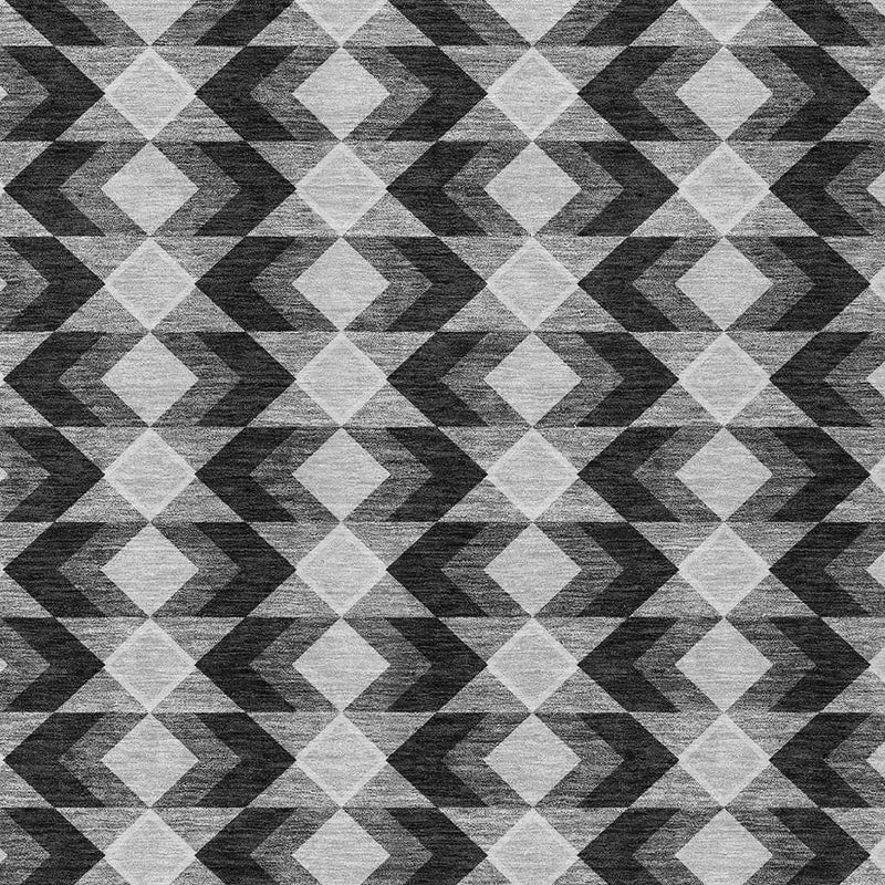 Geometric area rug with repeating diamond and chevron pattern in black, gray, and white.