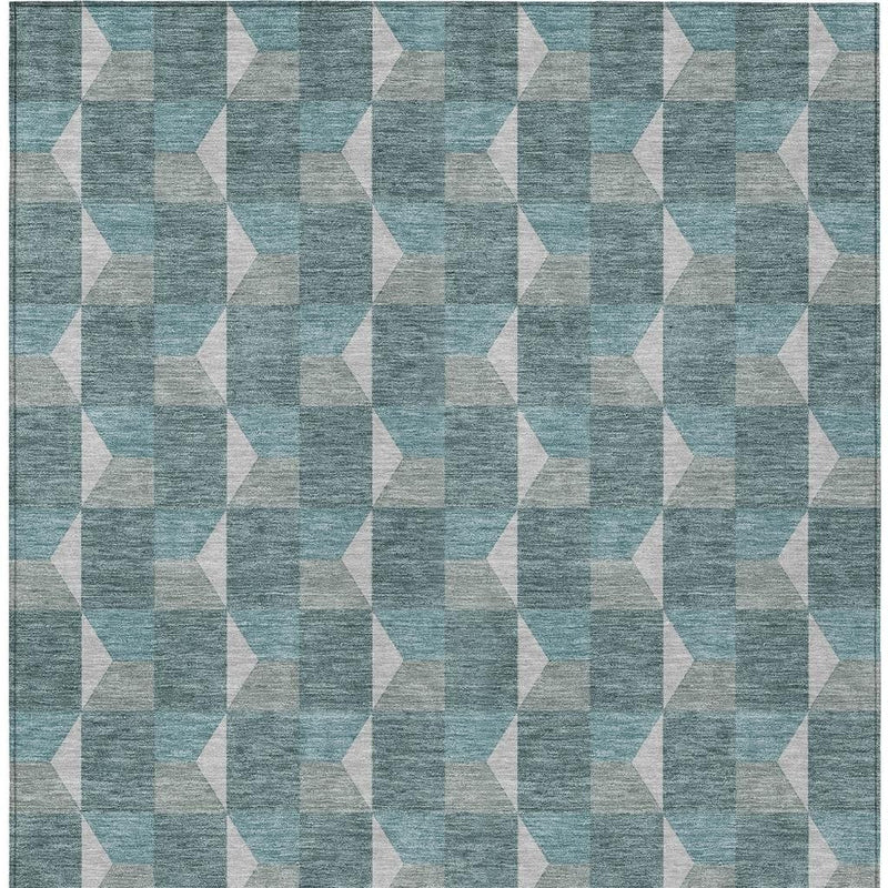 Teal geometric area rug pattern with interlocking white shapes, tight close-up