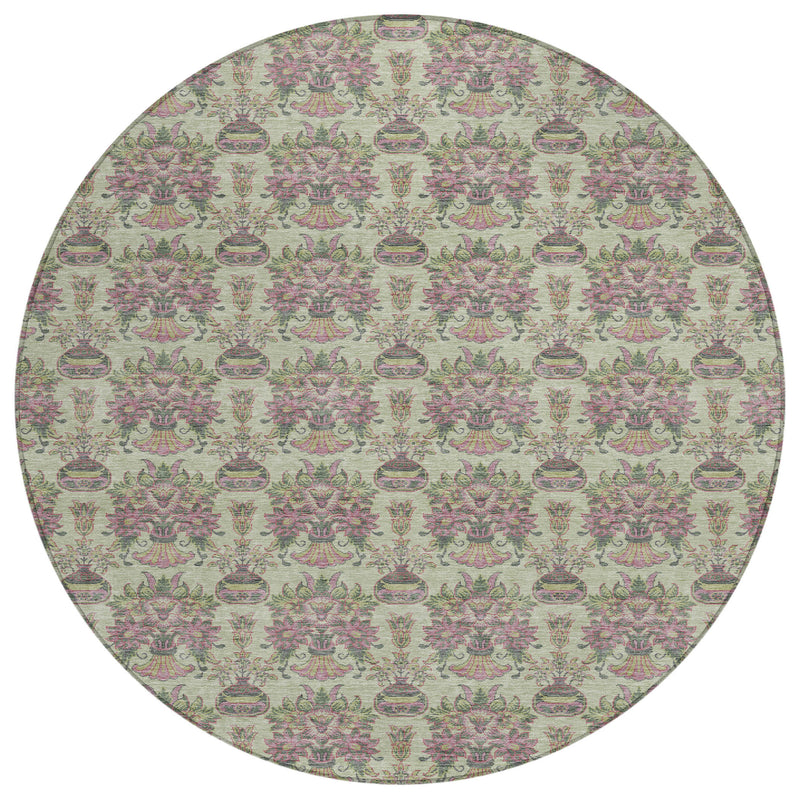 Full view of round area rug with repeating floral medallion pattern in green, beige, and pink
