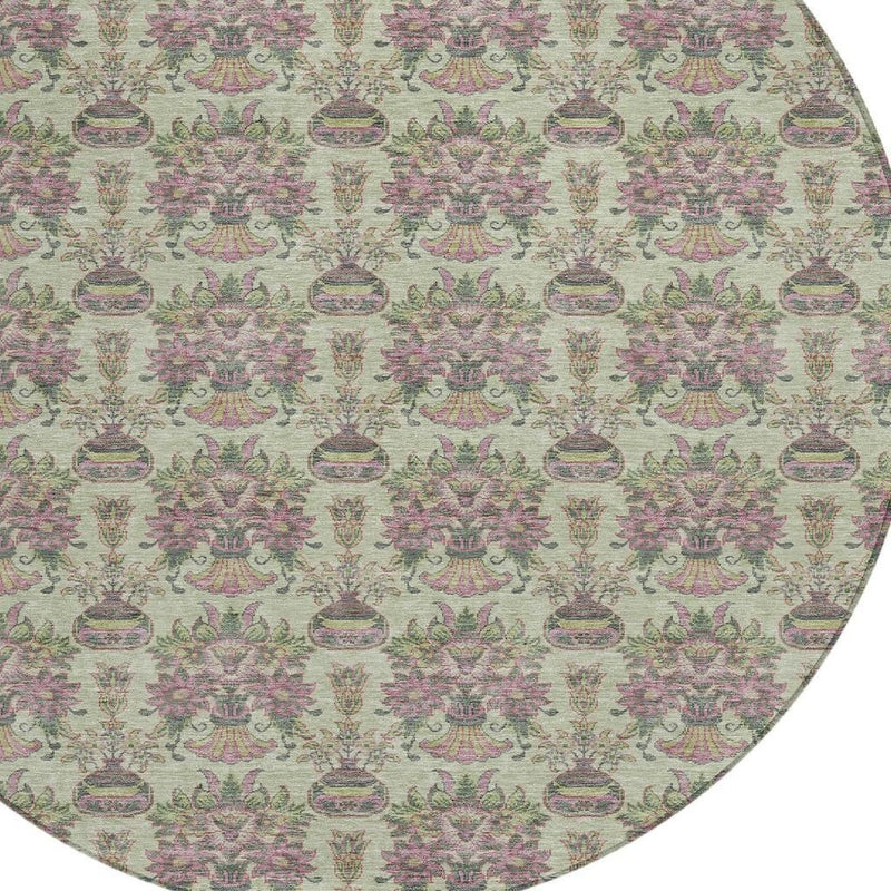 Curved edge close-up of round rug with dense floral medallion pattern in green and pink