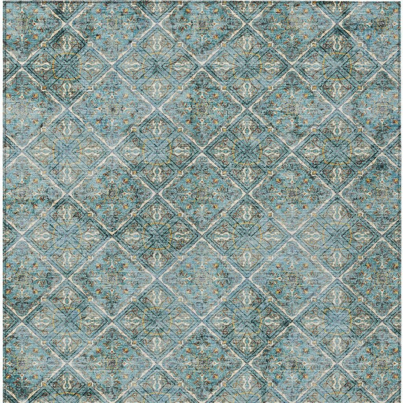 Teal blue area rug with repeating geometric diamond motif in cream and gold tones