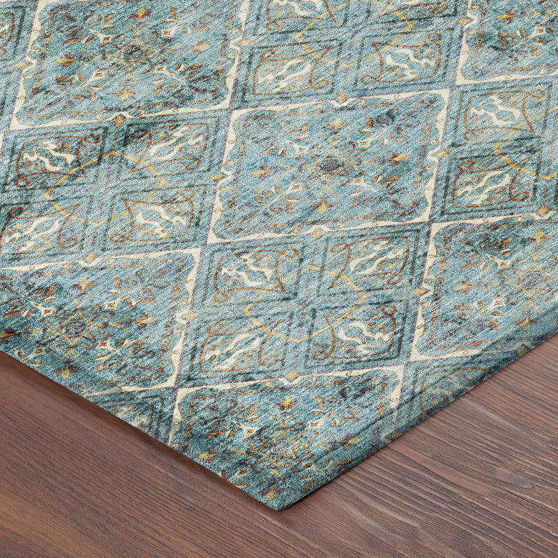 Corner of teal round area rug with diamond geometric motif and distressed multicolor detailing