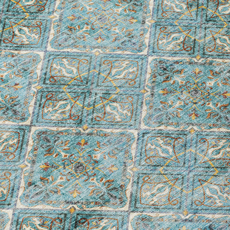 Close-up of teal diamond geometric pattern on a round area rug with distressed gold accents