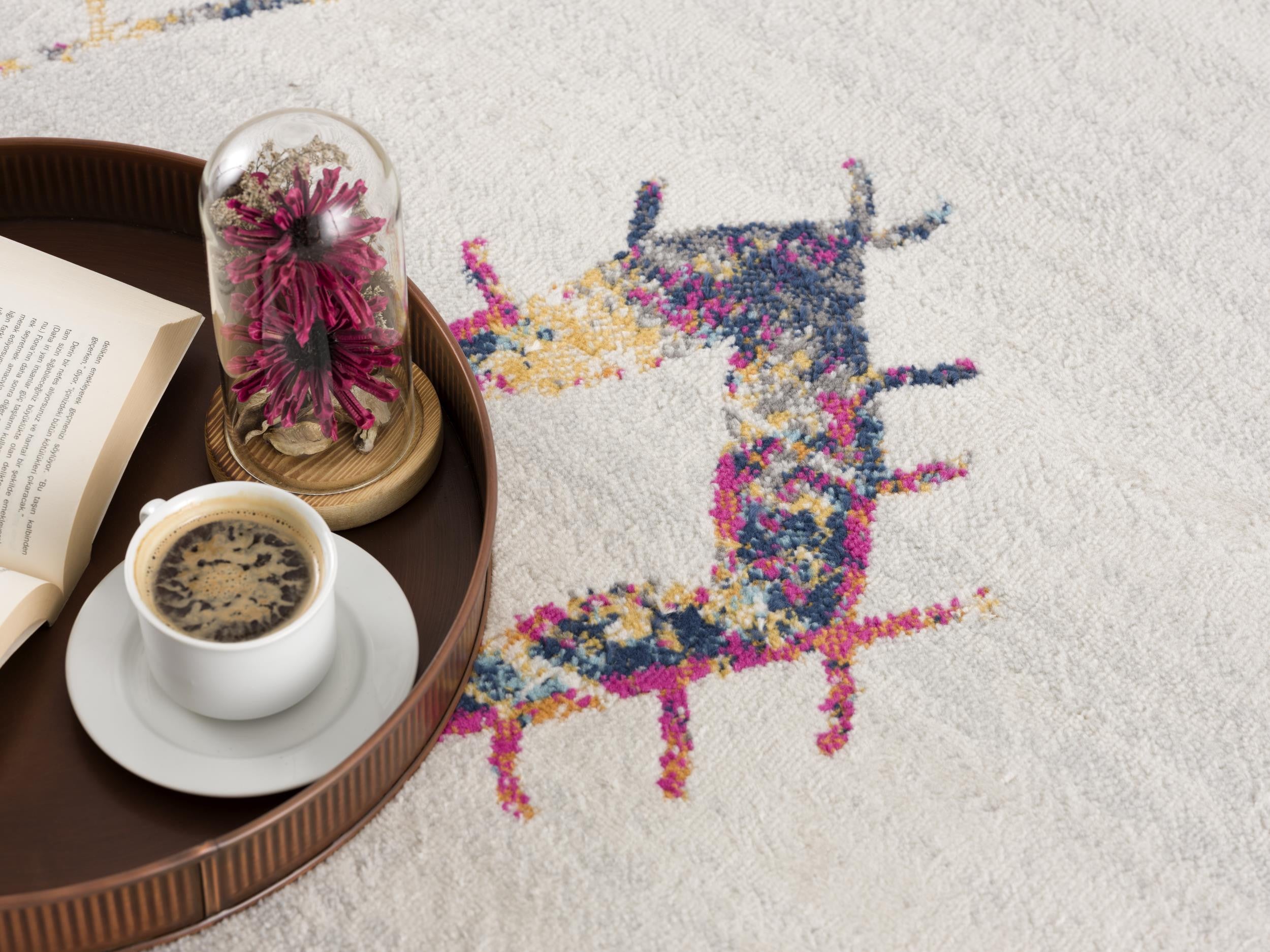 Colorful patterned area rug with a bohemian style, complemented by a coffee cup and decorative cloche on a wooden tray.