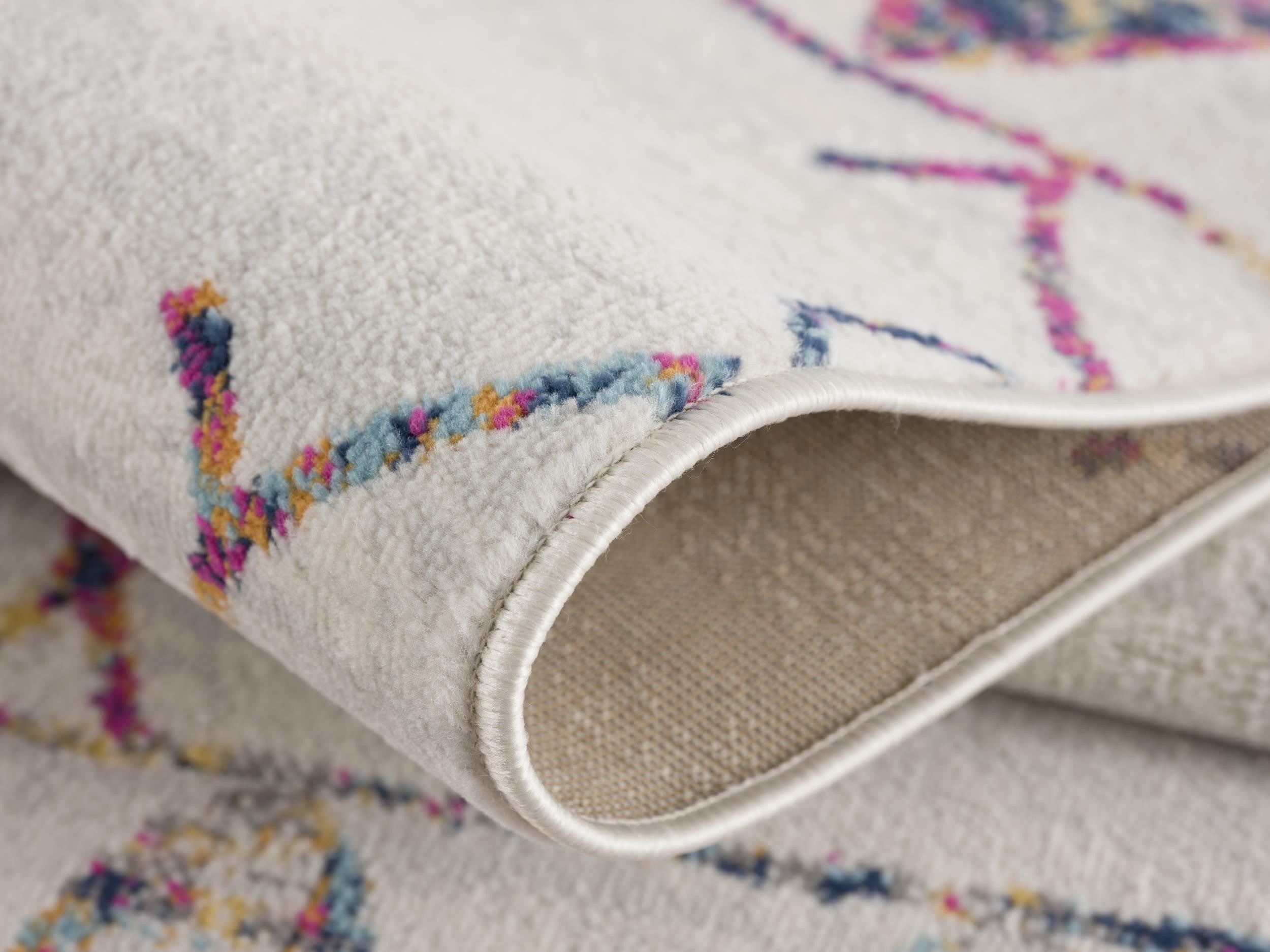 Multicolor abstract design area rug in soft cream, featuring plush texture and durable construction. Ideal for modern decor.