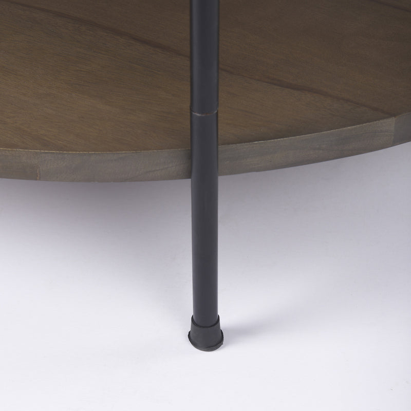 Round coffee table: black iron leg with circular base on white floor, dark wood apron
