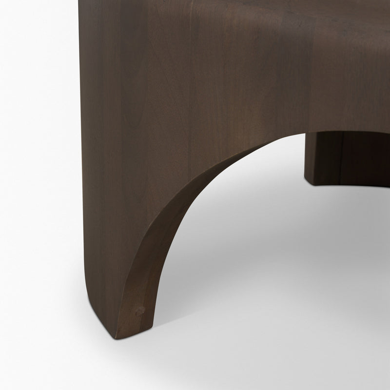 Dark brown solid-wood oval coffee table corner with curved apron cutout.