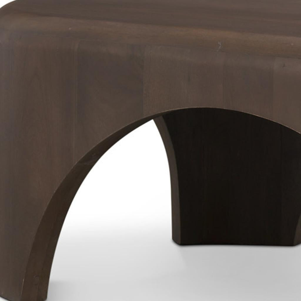 Brown oval coffee table with curved apron cutout and dark underside panel.