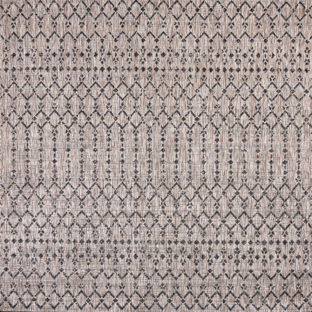 Close-up of diamond trellis area rug in beige with black crosshatch details