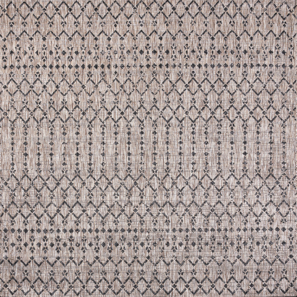 Indoor-outdoor area rug with repeating diamond trellis pattern in beige and dark gray