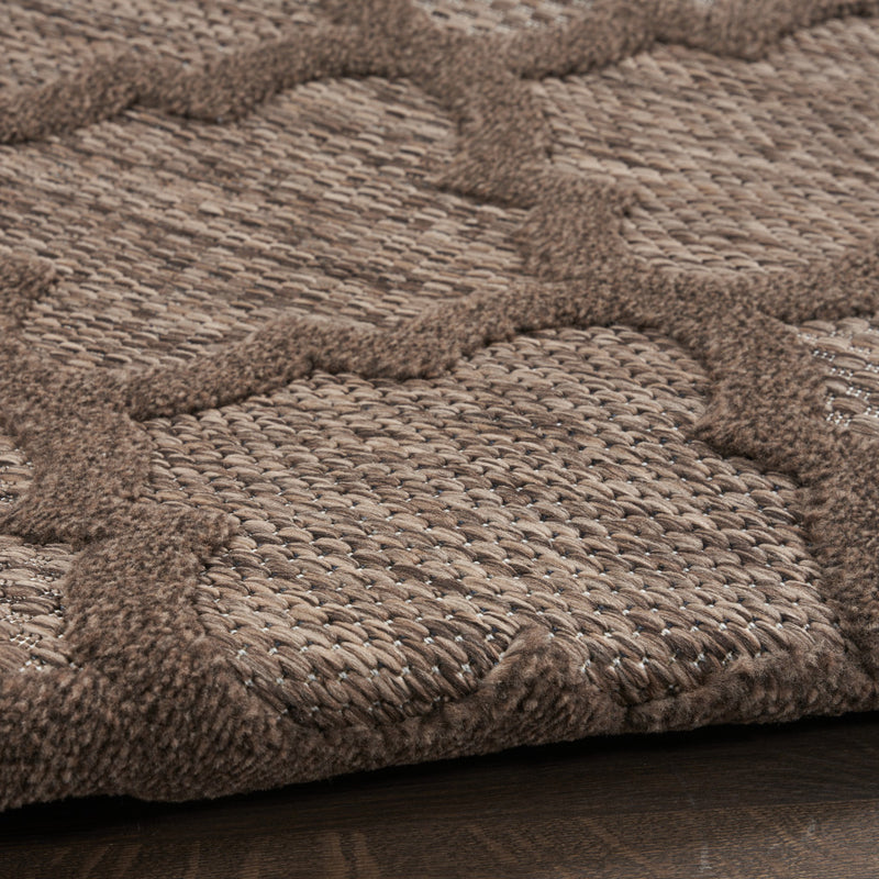 Close-up of round rug surface with woven texture and mottled brown tones