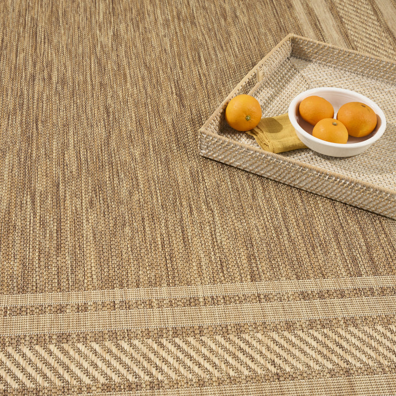 Natural woven area rug with textured weave and geometric border detail