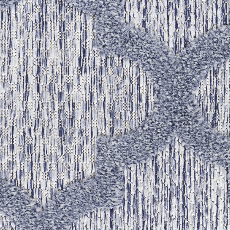 Blue indoor/outdoor rug close-up with textured raised quatrefoil pattern and short fibers