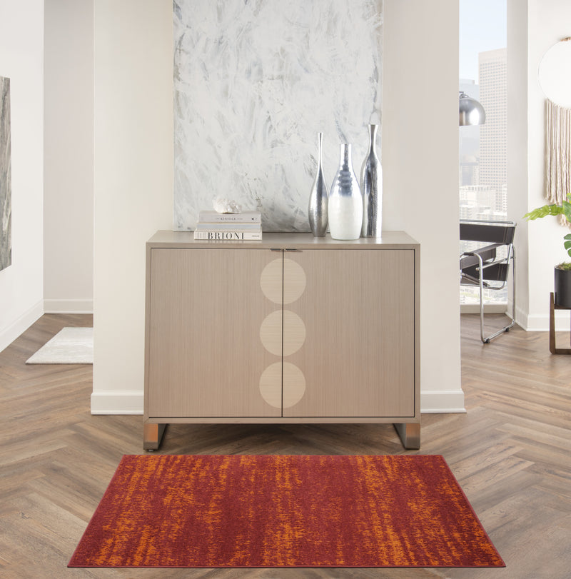 Abstract area rug in red and orange, laid on wood floor