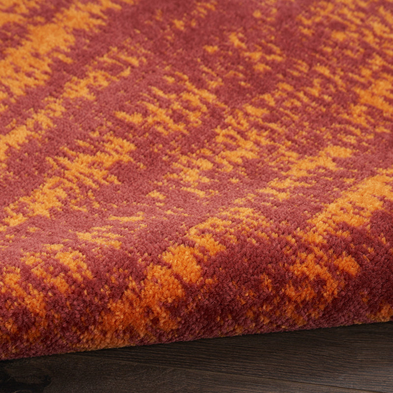Area rug pile close-up, rust-red and orange speckled textured surface