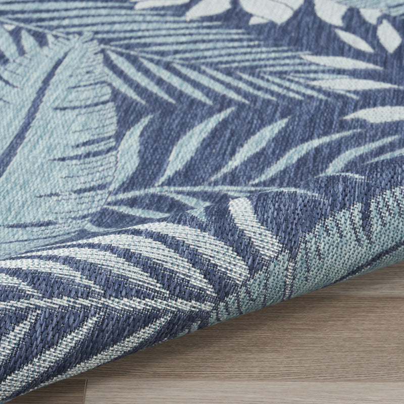 Navy and ivory leaf-pattern area rug with woven texture and bound edge