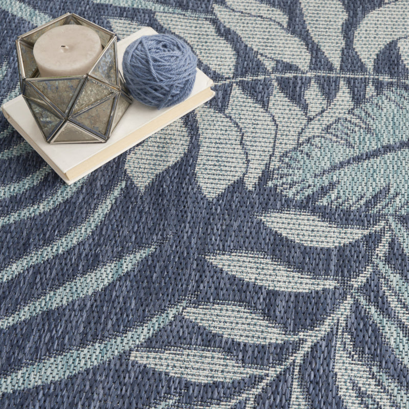 Navy and ivory botanical area rug with detailed leaf lines and woven surface