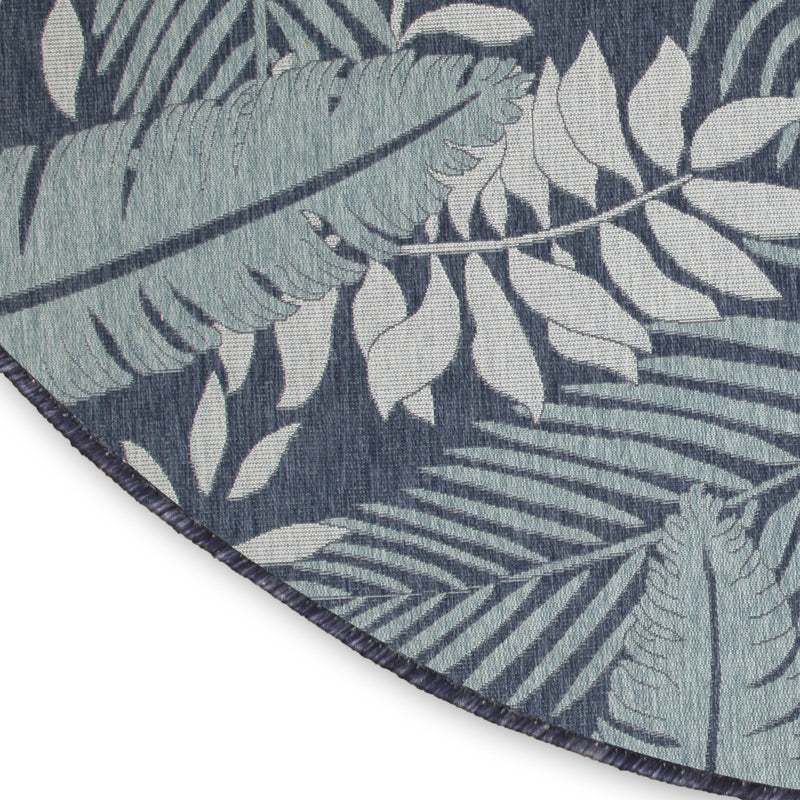 Round rug corner with navy edge trim and ivory leaf and fern pattern