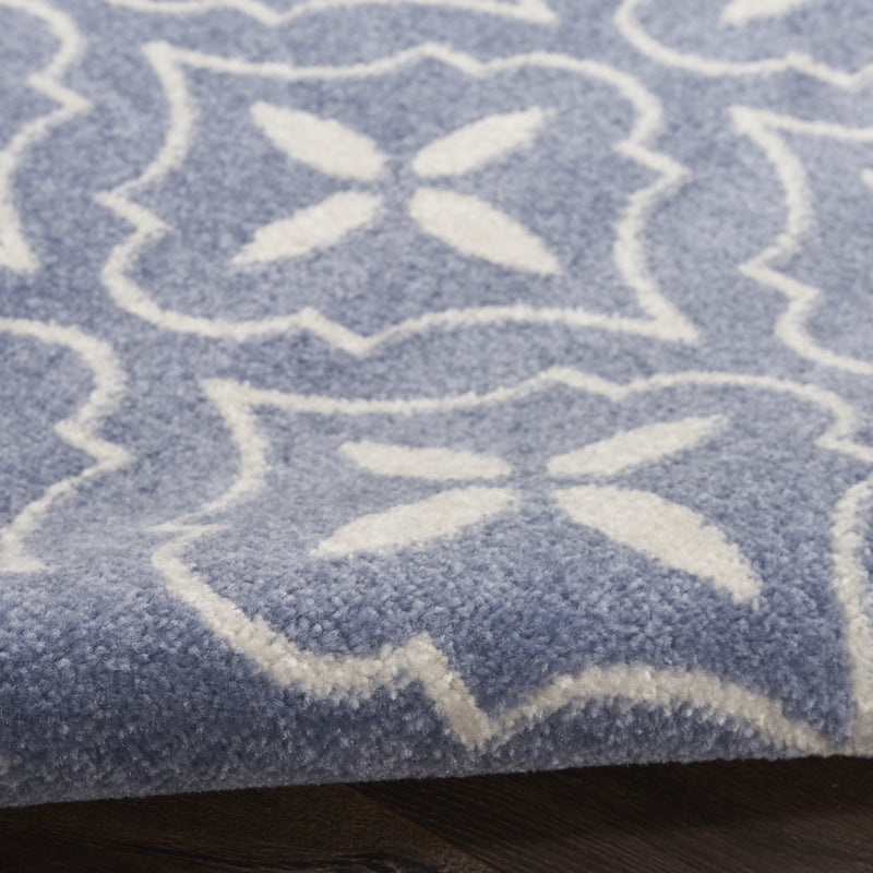 Blue and ivory geometric area rug detail, raised textured pile with quatrefoil shapes