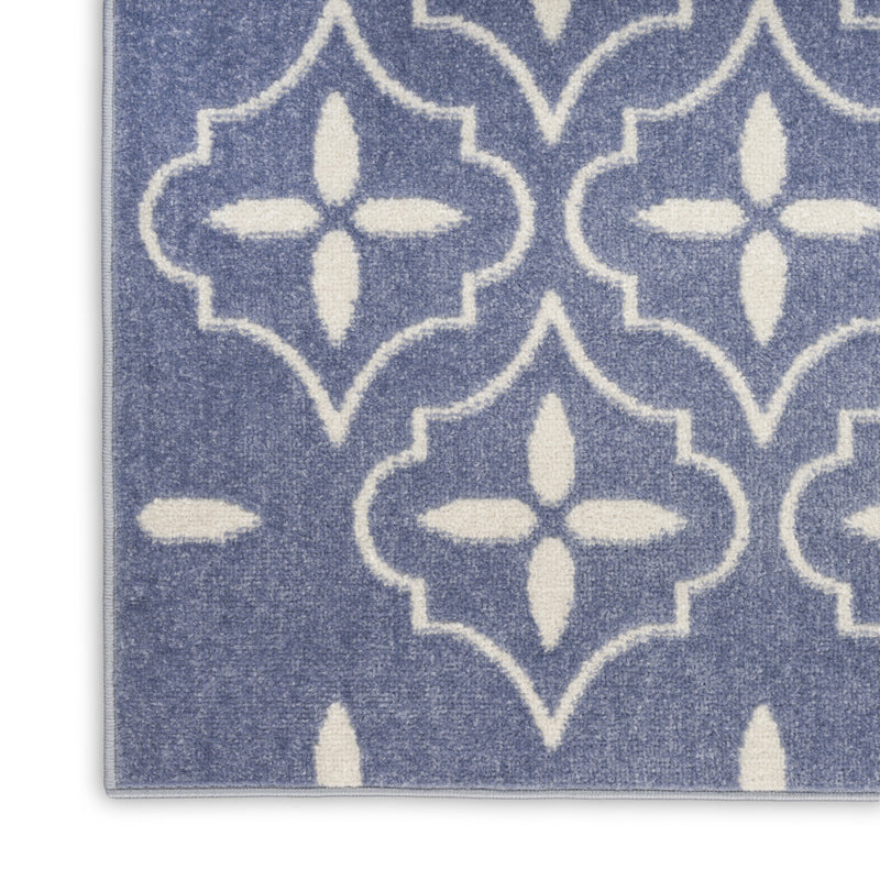 Blue and ivory geometric area rug corner, quatrefoil pattern with flat border edge