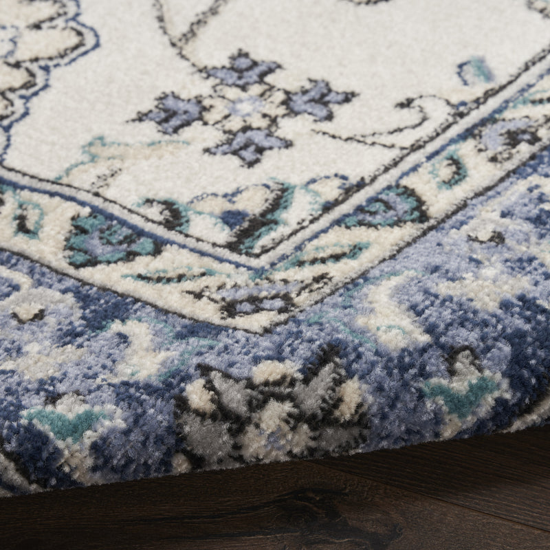 Close-up of ivory and blue floral rug texture and patterned border edge