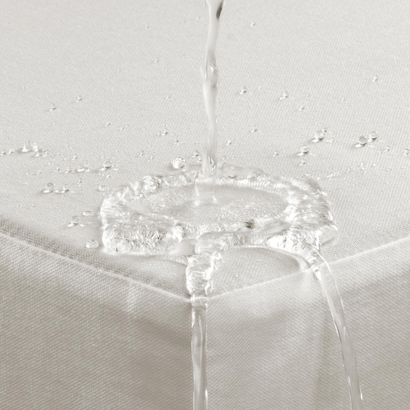 Outdoor cushion fabric detail with water droplets on light-colored upholstery