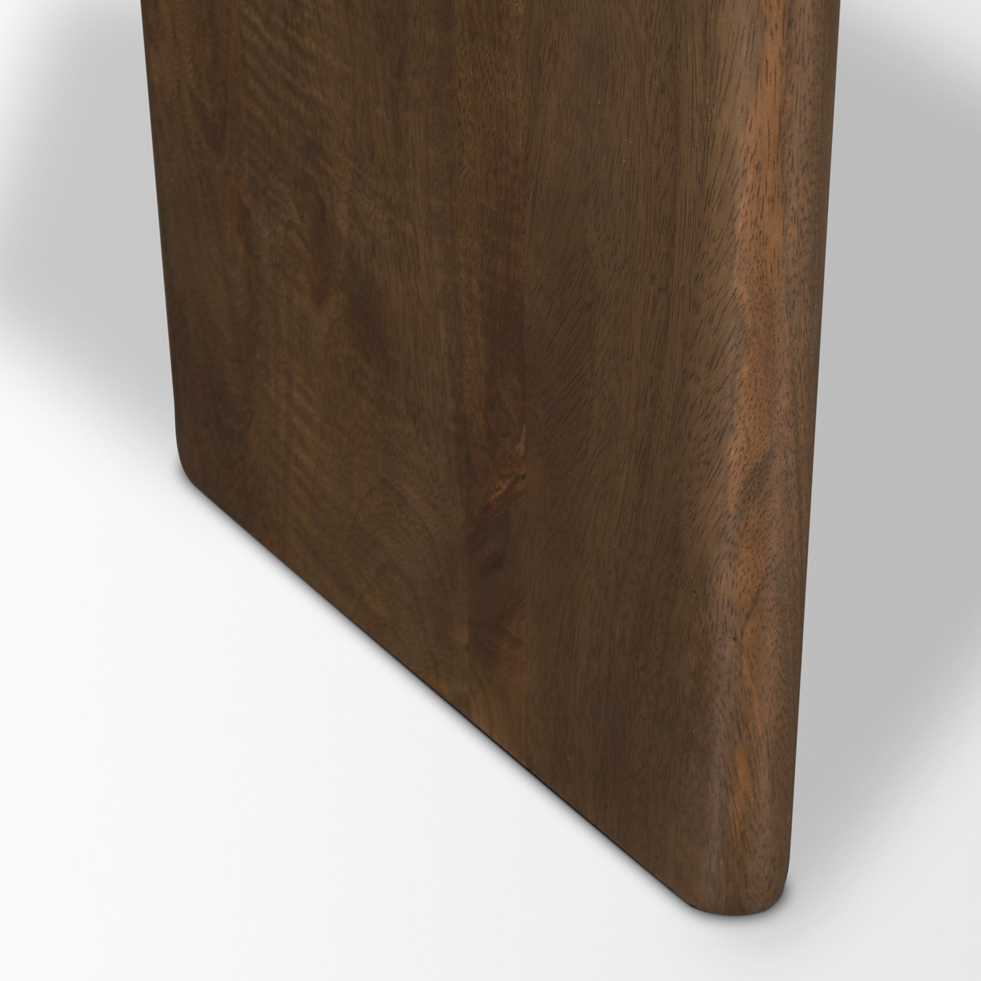 Close-up of dark brown wood table leg corner with curved bottom edge