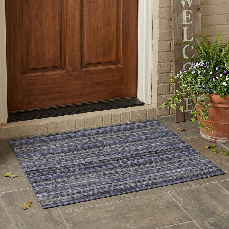 Blue and beige striped area rug placed indoors on a stone floor