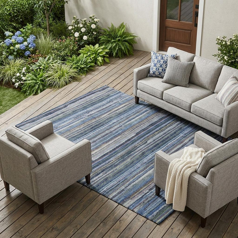 Blue and gray striped outdoor area rug on patio floor under sofa