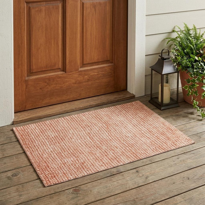 Rectangular orange and salmon textured area rug for indoor or outdoor spaces