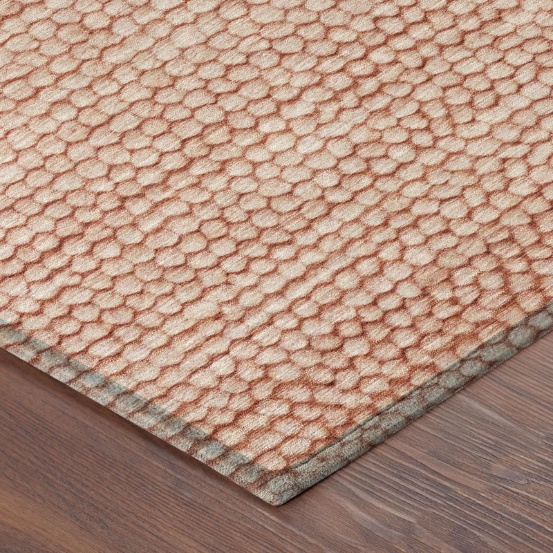 Corner view of orange and salmon patterned area rug with pebble texture