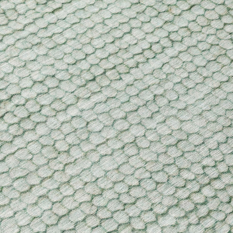 Rug texture close-up showing green and blue pebble-like raised pattern