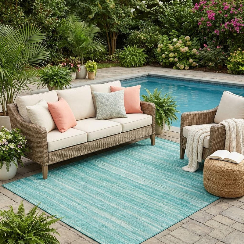 Teal and aqua striped area rug outdoors on patio, visible in full layout