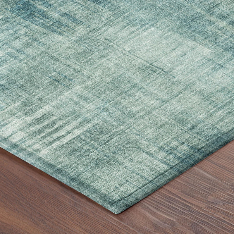Teal blue abstract area rug with distressed lines and visible corner fold