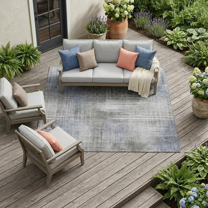 Indoor outdoor area rug with abstract gray-blue washed design and textured pile