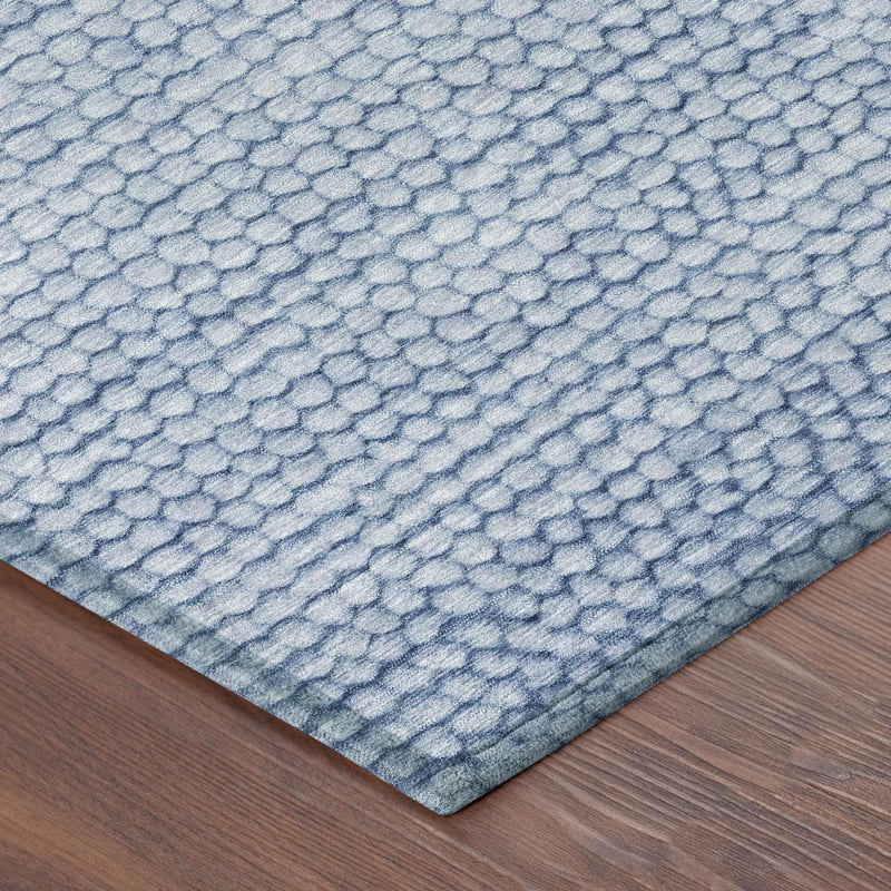Corner detail of blue washable indoor/outdoor area rug with pebble-textured weave