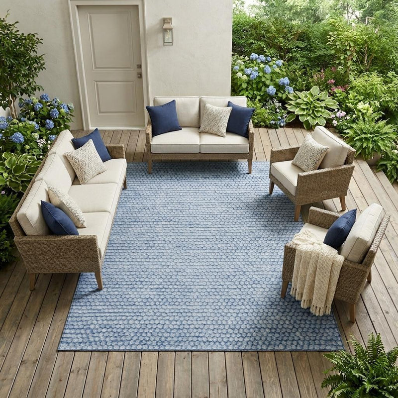 Blue washable indoor/outdoor area rug under outdoor patio seating