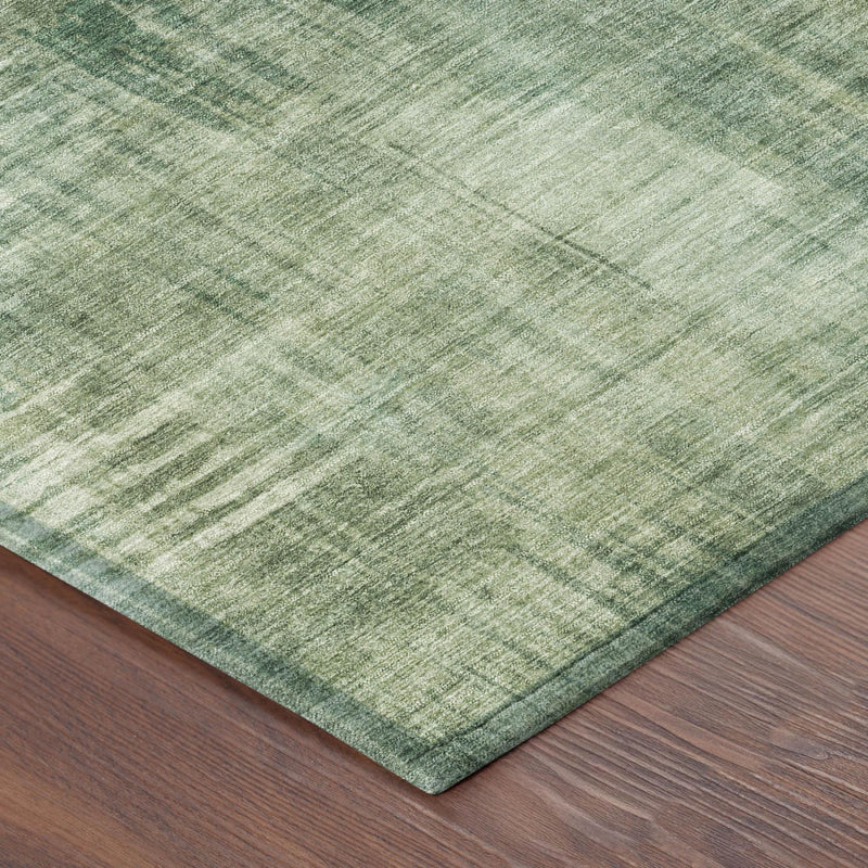 Fern green abstract area rug corner with distressed pattern and bound edge