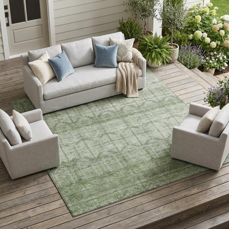 Sage green indoor outdoor area rug with tribal geometric pattern and distressed finish