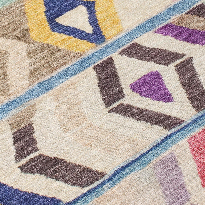 Close-up of round area rug showing multicolor geometric tiles with blue border and beige base
