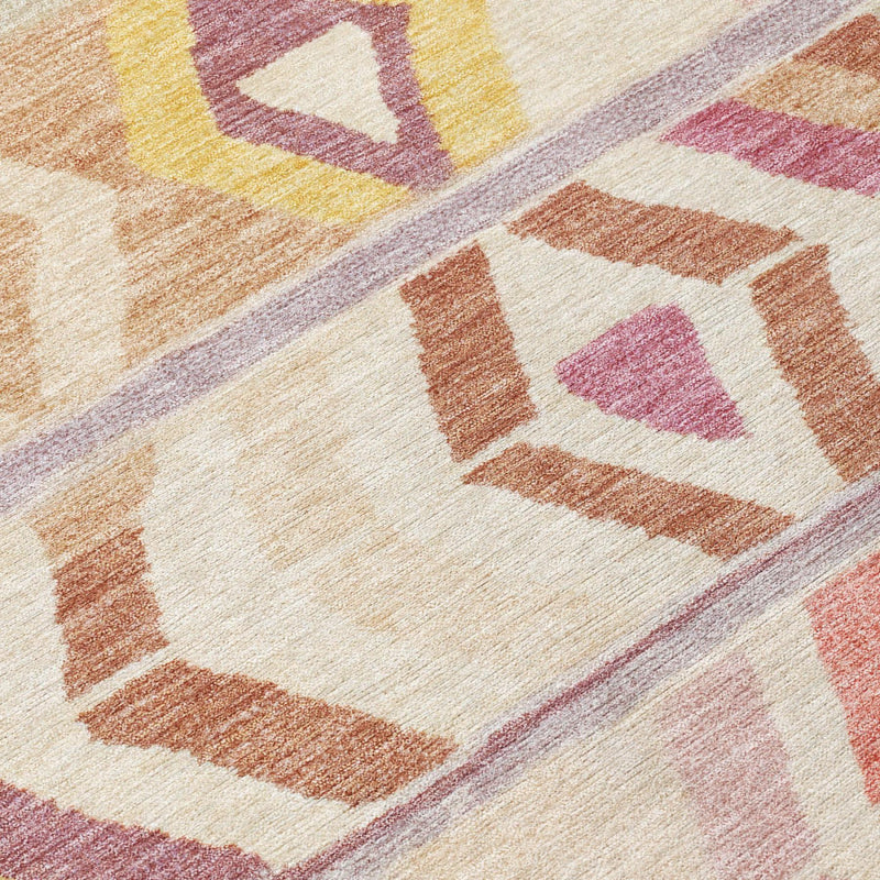 Round area rug texture close-up, cream with orange and pink geometric blocks
