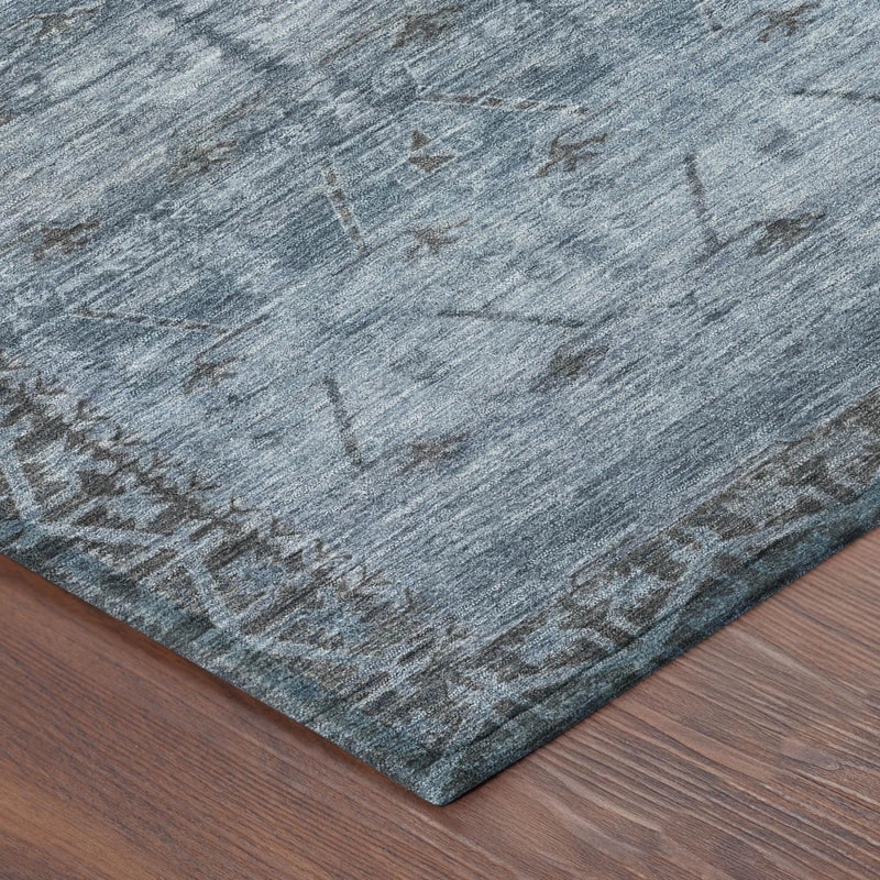 Blue and gray tribal area rug corner with distressed pattern and low pile texture