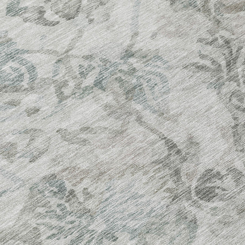 Close-up of light taupe area rug with muted teal floral motifs