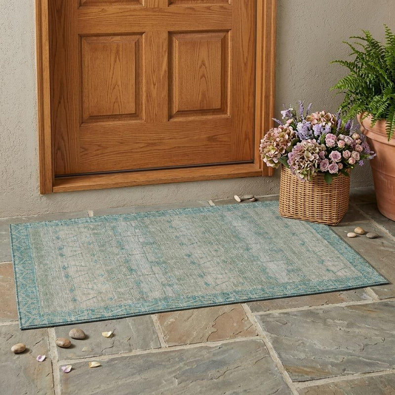 Teal blue and pewter tribal area rug laid indoors on stone tile floor