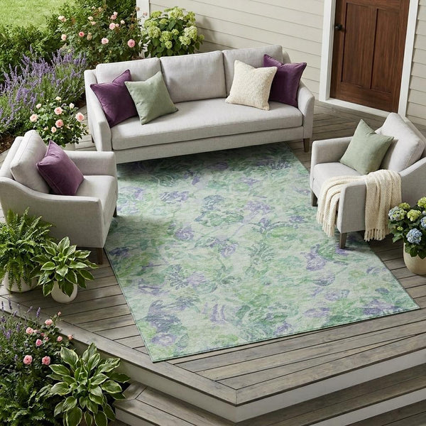 Indoor/outdoor floral area rug in mint green and blue-violet on an outdoor patio